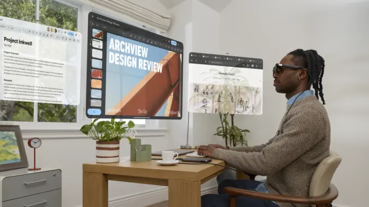 Man wearing XREAL AURA at a desk, surrounded by illustrated virtual app windows